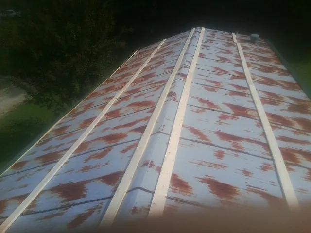 Rusted metal roof panels with new wood purlins before replacement — Storm Damage Roof Repair in Reynoldsburg by Roofing Brothers