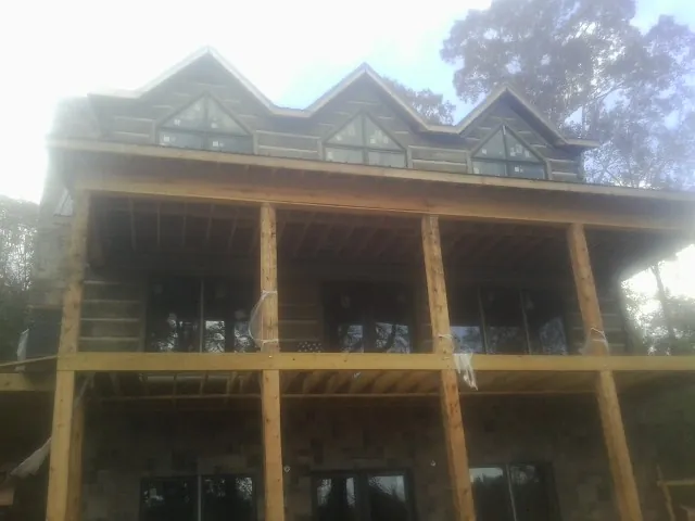 Dormers and porch framing on a large log home under construction — Roof Coating work by our crew in Reynoldsburg