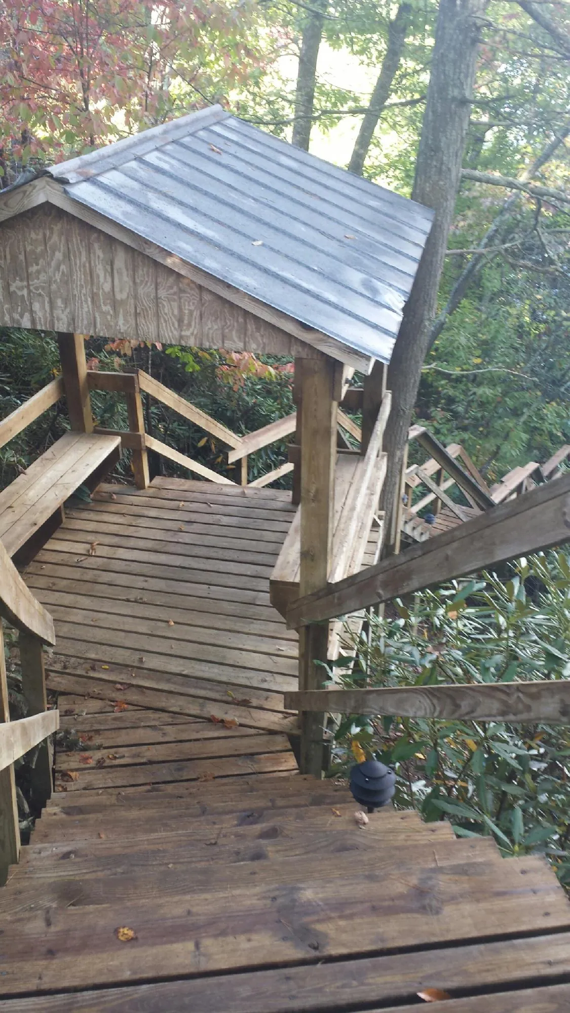 Metal roofed shelter over wooden steps on a wooded walkway — Skylight Repair & Installation work by our crew in Reynoldsburg