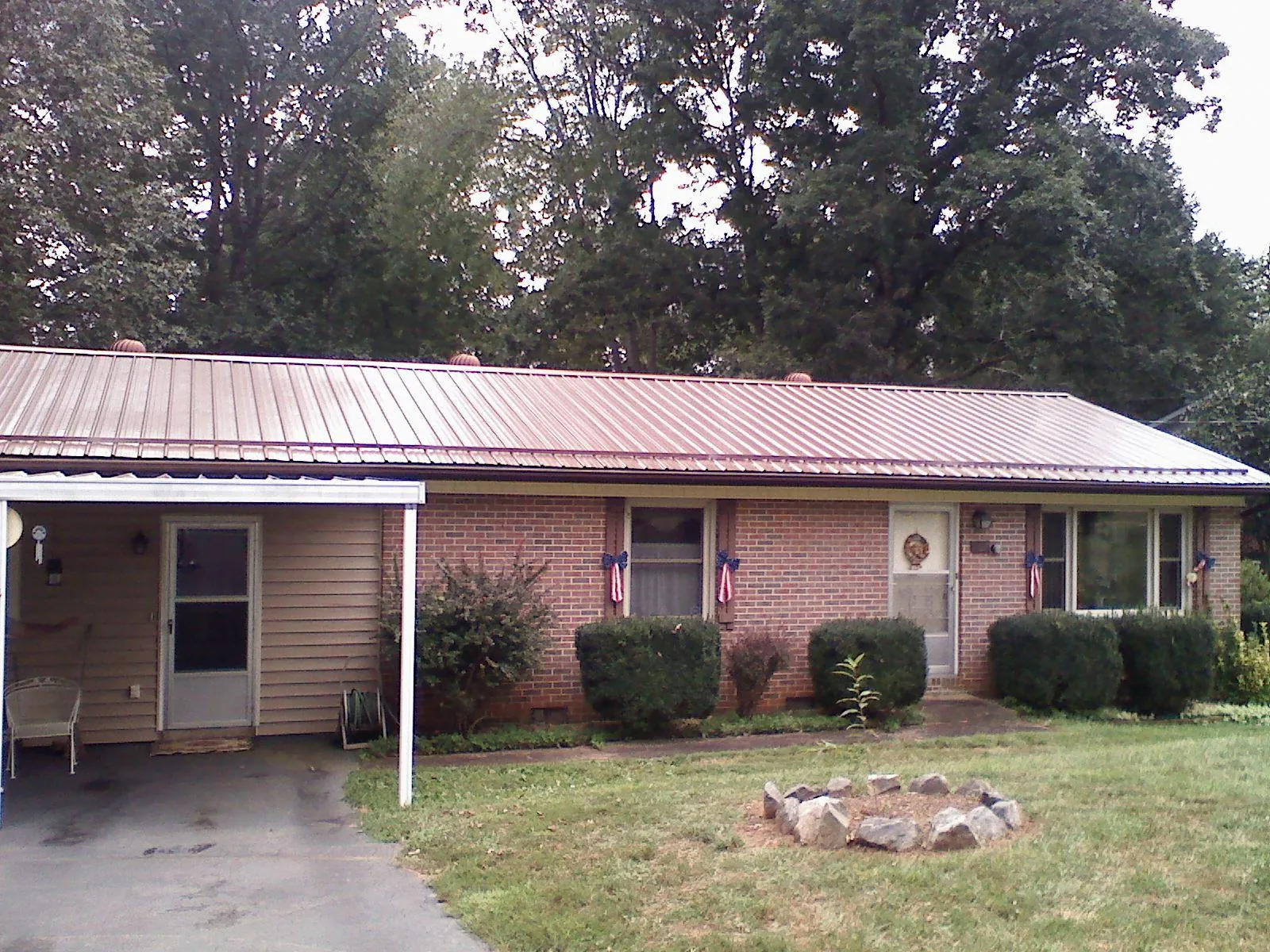 Bronze metal roof and carport on a brick ranch home — Roof Repair work by our crew in Reynoldsburg